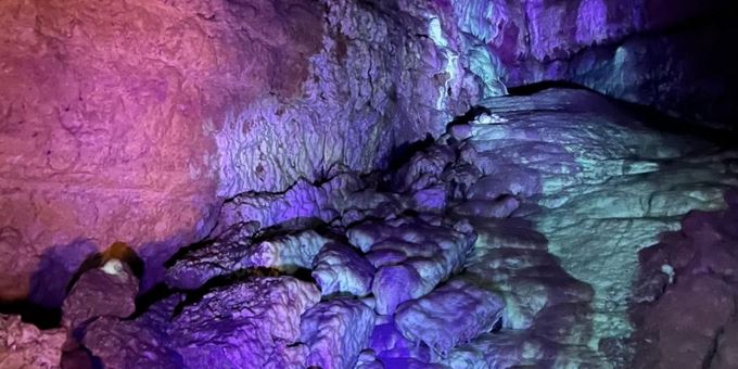 Flowstone glows under blacklight at Cave of the Mounds. Under purple UV light, the cave formations glow green.